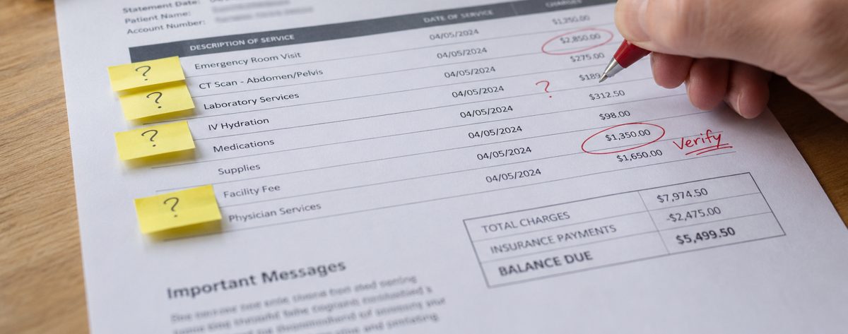A hand marking an itemized medical bill with a red pen, with question-mark sticky notes on several line items